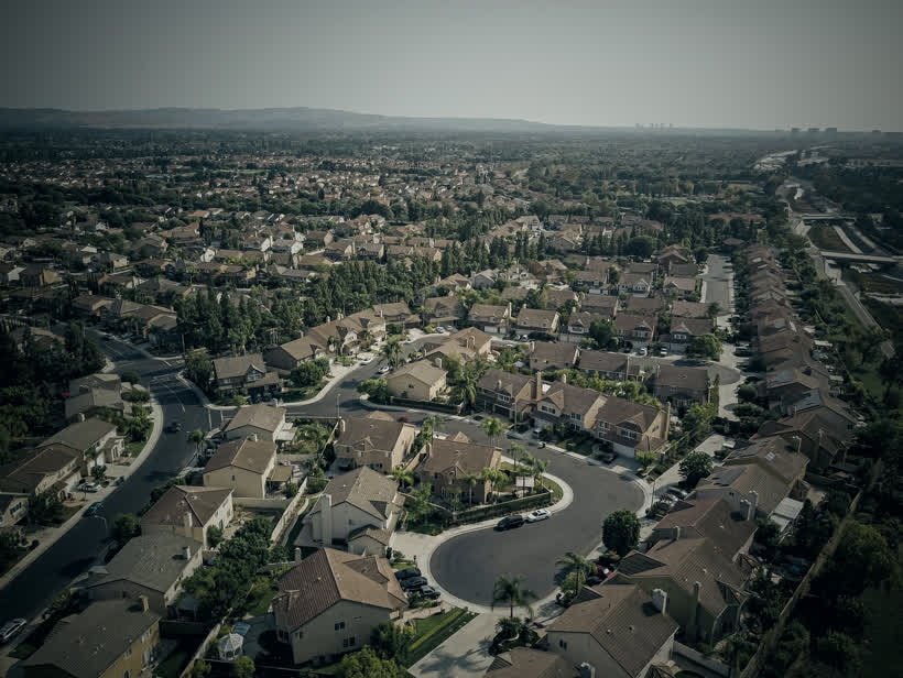 Vista aérea de um bairro residencial com casas, ruas e árvores