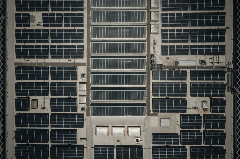 Vista aérea de perto do telhado de um galpão coberto de painéis solares